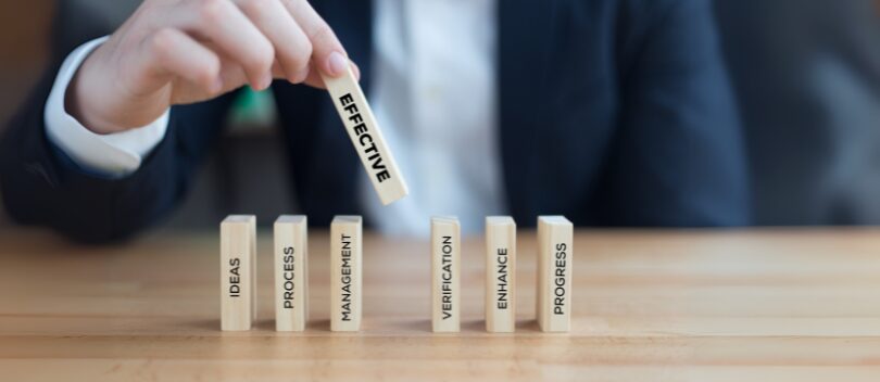 Director placing a block with the word 'effective' onto a table