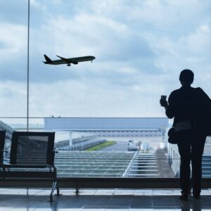 Silhouette of person watching airplane fly