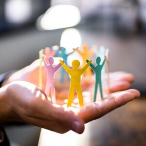 Group of paper people standing in a circle holding hands symbolising diversity