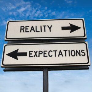 Signs that say reality and expectations pointing opposite ways 